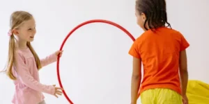 Two children playing with a hoop to encourage physical activity for childhood obesity prevention